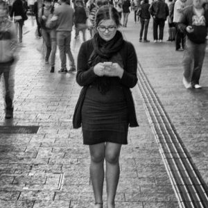 black and white photo of a single woman on her phone