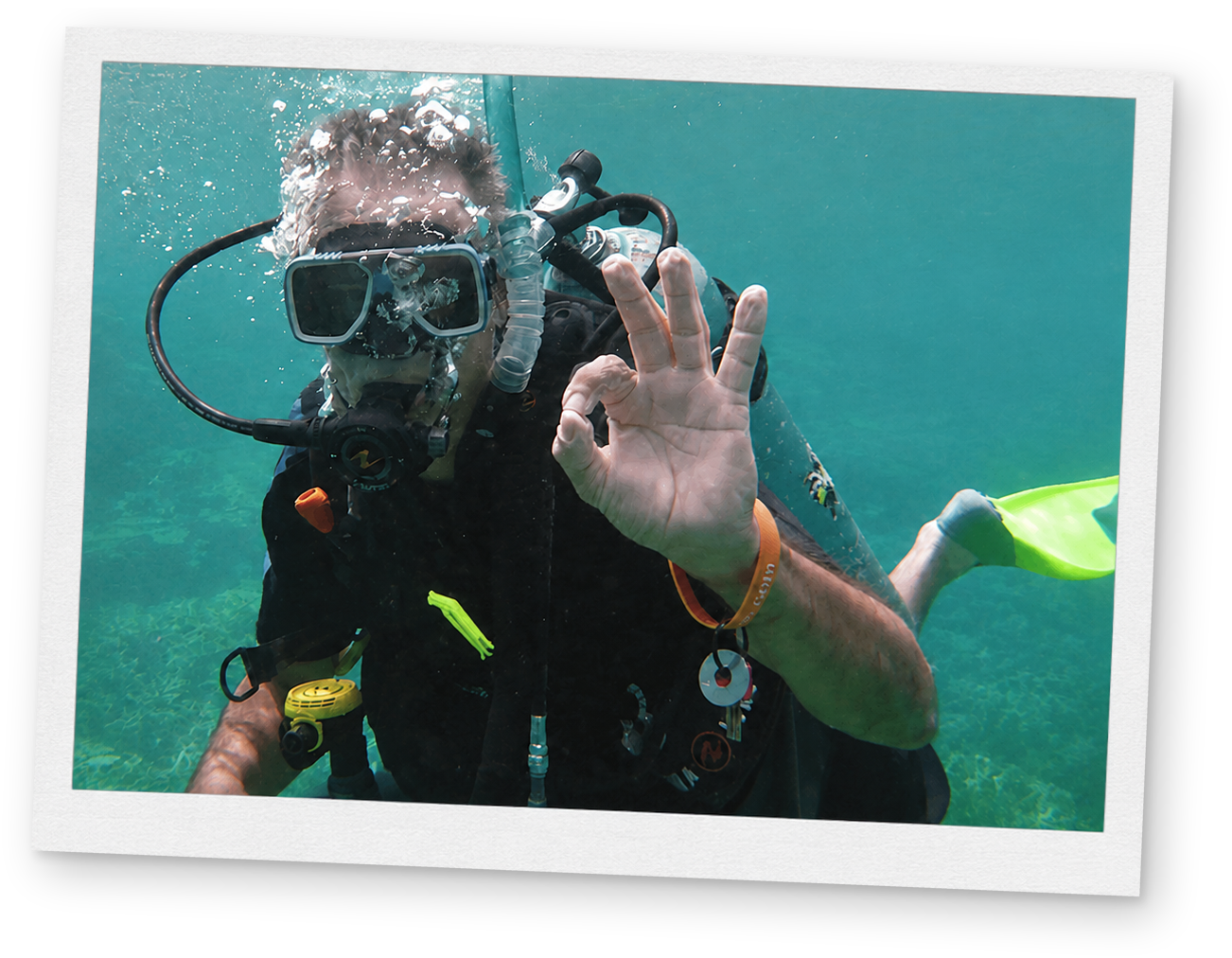 A scuba diver underwater giving the OK hand signal.
